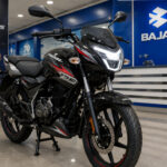 नई Updated Bajaj Pulsar 125 एक Bajaj डीलरशिप के अंदर डिस्प्ले पर खड़ी है। बाइक का नया LED हेडलाइट, नया फ्रंट डिजाइन और स्पोर्टी ग्राफिक्स साफ दिखाई दे रहे हैं। बैकग्राउंड में Bajaj Showroom का माहौल।