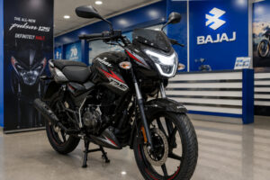 नई Updated Bajaj Pulsar 125 एक Bajaj डीलरशिप के अंदर डिस्प्ले पर खड़ी है। बाइक का नया LED हेडलाइट, नया फ्रंट डिजाइन और स्पोर्टी ग्राफिक्स साफ दिखाई दे रहे हैं। बैकग्राउंड में Bajaj Showroom का माहौल।
